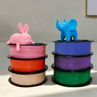 Assorted PLA filament colors with printed rabbit and elephant models